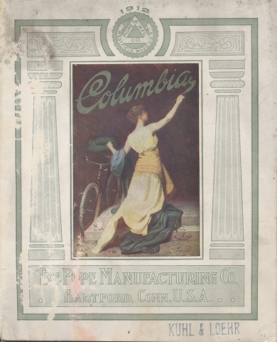 Cover of Columbia bicycle catalog, 1912, showing a woman kneeling painting the words "Columbia" while crowning a bicycle with a laurel wreath.