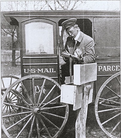 BW photo of post man half sitting in US Mail cart