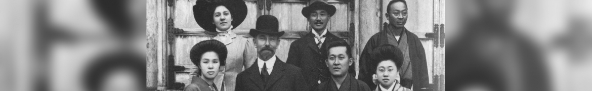 Seven people dressed in early 1900's japanese and western clothing
