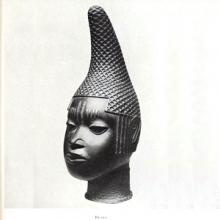 Bronze portrait bust of a person with a textured conical hat, from Benin.