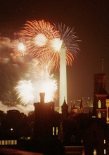 Fireworks illuminate the Washington Monument in Washington DC. In the foreground is the silhouette of the Smithsonian Castle.