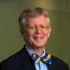 Headshot of a man in a suit with a blue and yellow bowtie